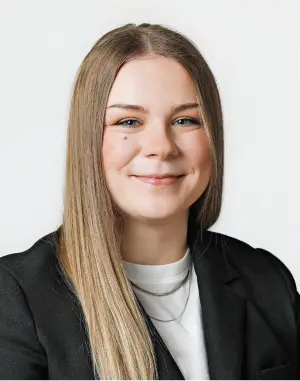 Professional headshot of Maddison with long dark blonde hair, wearing a black jacket and white shirt, smiling.