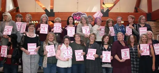 Group of people holding signs with numbers representing years.